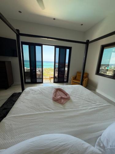 a bedroom with a bed with a pink towel on it at White Sky Beach Villas in Culloden