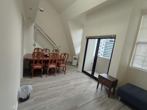 Un comedor con mesa y sillas en 3 Double Beds and 1 Single Bed and 2 Double Sofa Beds in a small 2 Bedrooms Penthouse, en Auckland
