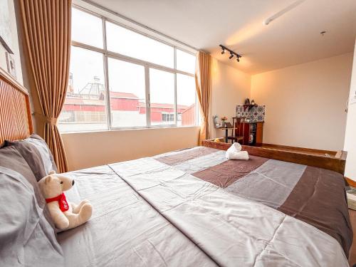 a bedroom with a large bed with a teddy bear on it at La Casa Di Dicembre 18 Hàng Cháo in Hanoi