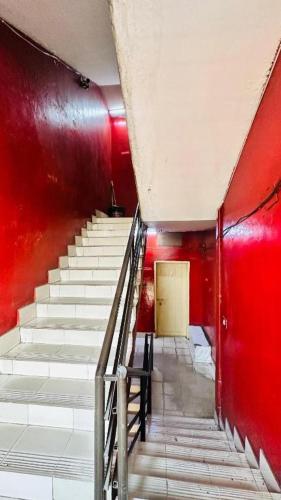 a staircase in a building with red walls and a door at Hotel Al Makka Dhaka in Dhaka
