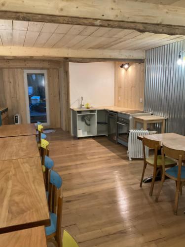 Il comprend une cuisine avec du parquet, une table et des chaises. dans l'établissement COMME CHEZ SOI, à Saint-Satur