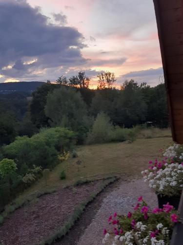a sunset over a field with flowers on a hill at Villa of Roses in Lanckorona