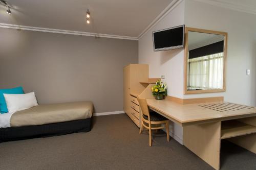 a room with a bed and a desk and a bed and a bed at Berri Hotel in Berri