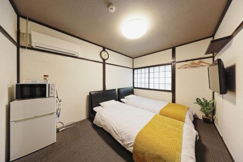 a bedroom with a bed and a clock on the wall at Kulton Apartment in Kanazawa