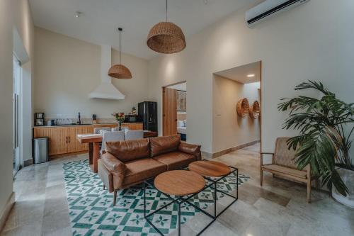 una sala de estar con un sofá y una mesa en Casa Mara Reforma con alberca, en Mérida