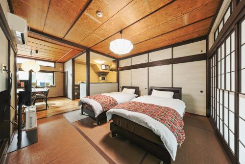 a bedroom with two beds and a desk in it at TAMACO in Kanazawa in Kanazawa