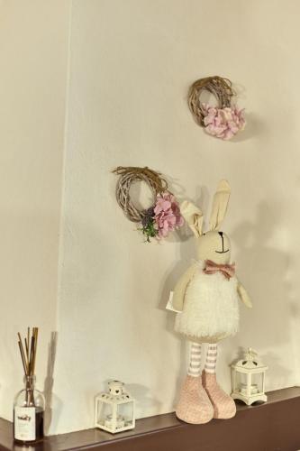 a shelf with two wreaths and a figurine of a bunny on top at La casina in Via Fiorita in Montepulciano