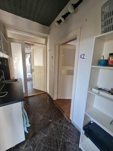 a kitchen with white cabinets and a door to a hallway at Guest Rooms in Private Home by Airport, Shared Bath, Non-Smoking, Contactless Check-in, No Staff, Quiet Stay, Short Stay in Kněžívka