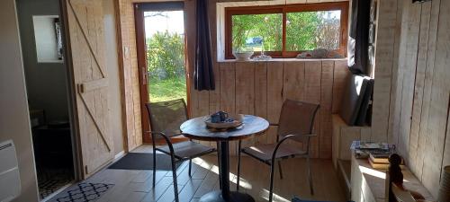 une petite table et des chaises dans une petite maison dans l'établissement Chambre cosy avec entrée indépendante, à Chaînée-des-Coupis