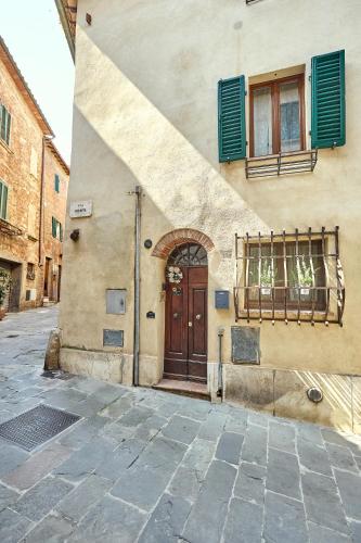 a building with a wooden door and a window at La casina in Via Fiorita in Montepulciano