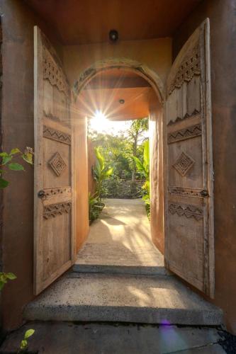 an open door to a house with an open doorway at Sun Sang Eco Retreats in Tabanan