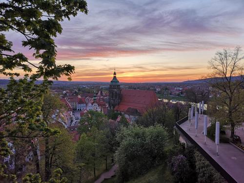 a view of a city at sunset with a clock tower at Pension Donatus in Pirna