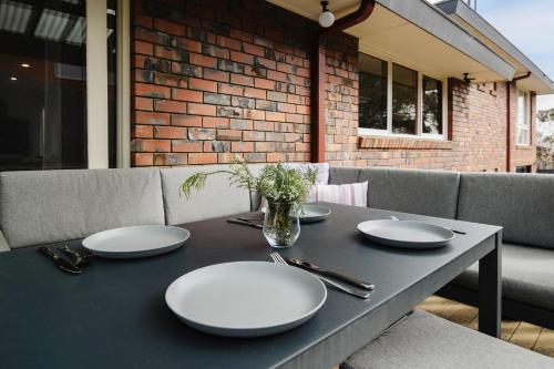 a table with plates and utensils on a patio at The Diamond of Diamond Creek in Diamond Creek