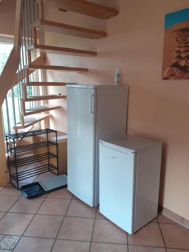 a white refrigerator in a room with a staircase at Ferienwohnung Ferienzimmer,nahe Rostock, Bentwisch Ot Albertsdorf bis 7 Personen in Bentwisch
