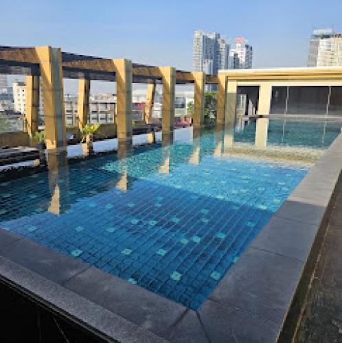 a large swimming pool on the roof of a building at Palette Bella B All Suites Bangkok Hotel in Bangkok