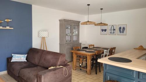 un salon avec un canapé et une table dans l'établissement GRAIN DE SABLE 600m des plages, et commerces,draps,vélos, WIFI , Parking, à Saint-Hilaire-de-Riez