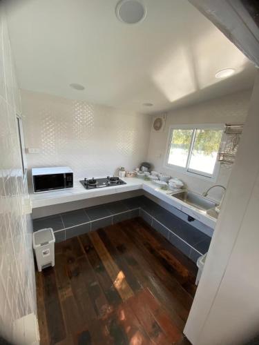 a small kitchen with a sink and a stove at ตอไม้คันทรีรีสอร์ท in Ban Maklua Mai