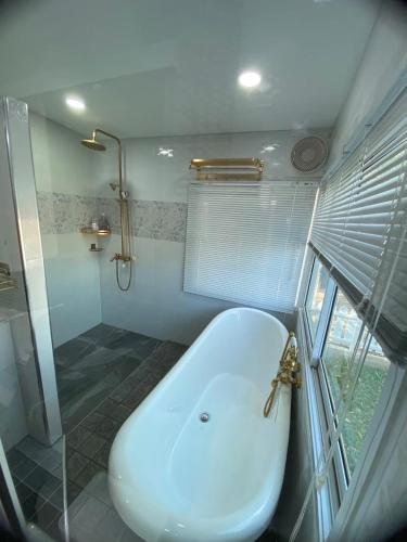 a bathroom with a toilet and a shower and a sink at ตอไม้คันทรีรีสอร์ท in Ban Maklua Mai