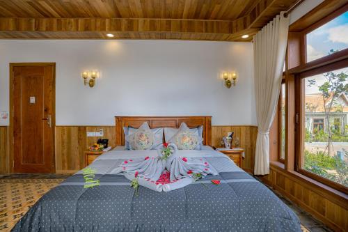 a bedroom with a large bed with a large window at KNN Luxury Hill in Sen Monorom