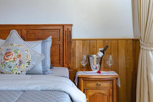 a bedroom with a bed and two wine glasses on a table at KNN Luxury Hill in Sen Monorom