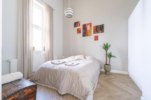 a white bedroom with a bed and a window at Stunning Loft with Water View & Free Garage Parking in Kuopio