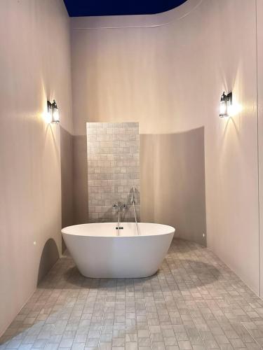 a large white tub in a bathroom with two lights at Reniva Pool Villa cha-am in Ban Bo Prakhon