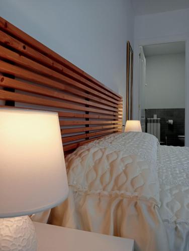 a bedroom with a white bed with two lamps at Anguiano Habitaciones rurales con baño privado in Anguiano