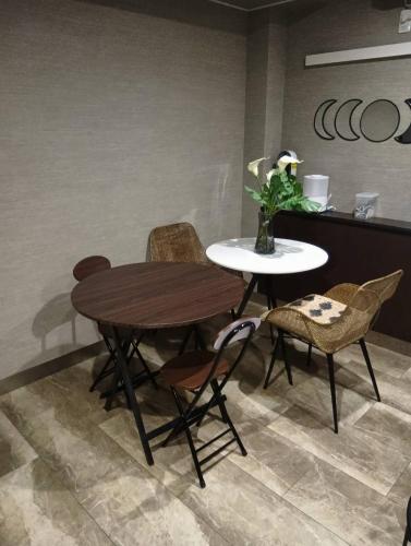 a table and chairs in a room with a table and a vase at The Masters Stay SETAGAYA KYODO in Tokyo