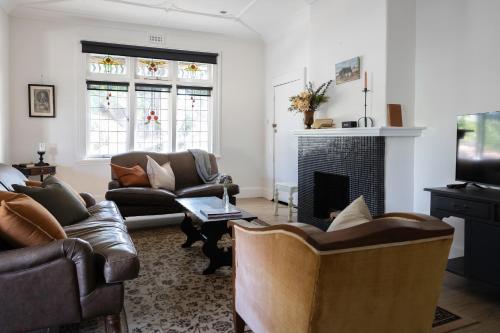 a living room with couches and a fireplace at Poets Corner vintage retreat walk to View St in Bendigo