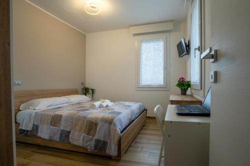 a bedroom with a bed and a desk with a laptop at Tra il verde ed il Balsamico in Spilamberto