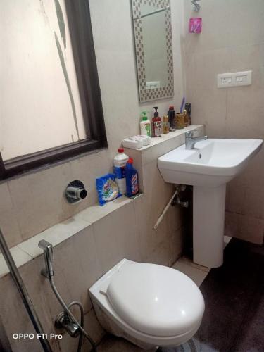 a bathroom with a white toilet and a sink at Nainital Cotteges in Rāmgarh