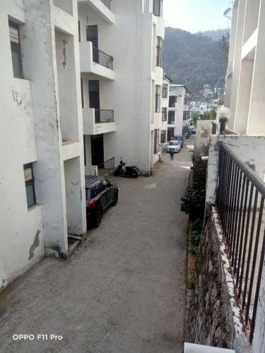 a car parked in a parking lot next to a building at Nainital Cotteges in Rāmgarh