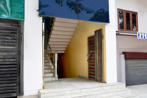 a building with stairs and a blue sign on the side at Super Collection O Govind Vihar Matiyari Formerly Saffron in Lucknow