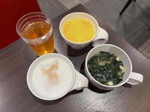 a table with two bowls of food and a drink at PORTA INN bentencho in Osaka