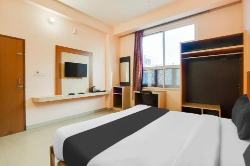 a hotel room with a bed and a large window at Super Hotel O JLN Marg Malviya Nagar Formerly Hotel Braj Haveli in Jaipur