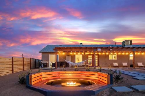 ジョシュア・ツリーにあるHigh Desert Hideout- Dreamer's Domeの夕日を背景にした焚き火台のある家
