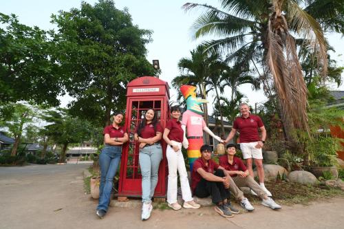a group of people posing in front of a telephone booth at Mina Resort and Spa in Loei