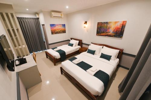 a hotel room with two beds and a television at Mina Resort and Spa in Loei