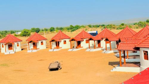a row of houses with red roofs in a field at Rann Riders in Rāpar