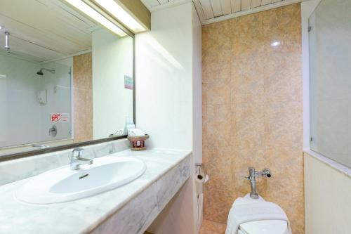 a bathroom with a sink and a toilet at Pinnacle Lumpinee Park Hotel in Bangkok