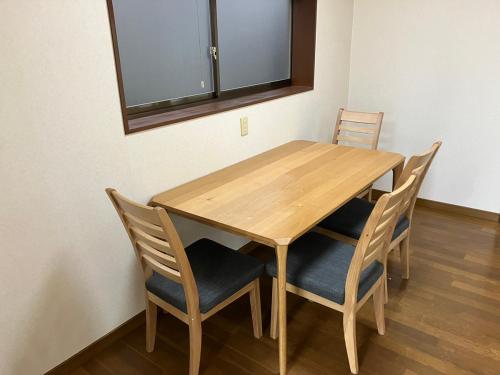 a wooden table and chairs in a room at 芦原温泉駅から徒歩5分の1棟貸切民泊 最低限芦原温泉駅前 in Awara