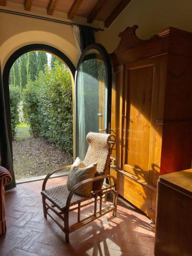 a chair sitting in a room with a window at Villa Poggio dei Cipressi in Subbiano