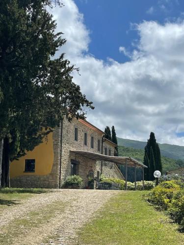 a stone building with a tree in front of it at Villa Poggio dei Cipressi in Subbiano