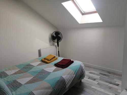 a bedroom with a bed and a skylight at Appartement climatisé avec parking privé gratuit in Doué-la-Fontaine