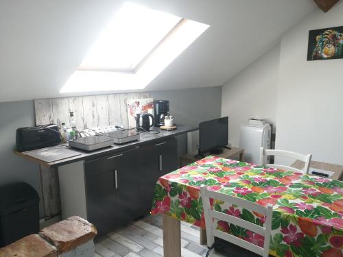 une cuisine avec un comptoir et une table avec une nappe dans l'établissement Appartement climatisé avec parking privé gratuit, à Doué-la-Fontaine