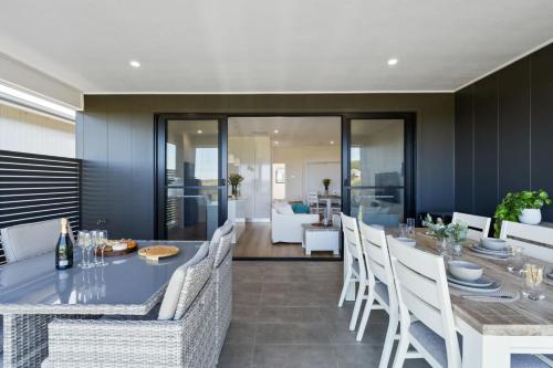 a dining room with a blue table and white chairs at Shell Cove Serenity by Links Golf Course & Marina in Dunmore