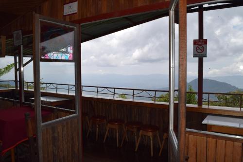 a balcony with chairs and a view of a mountain at Mirador Valle del General in La Ese