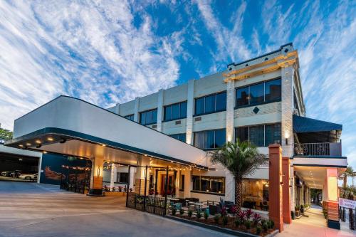 a large white building with a palm tree in front of it at St Charles Coach House, an Ascend Collection Hotel in New Orleans