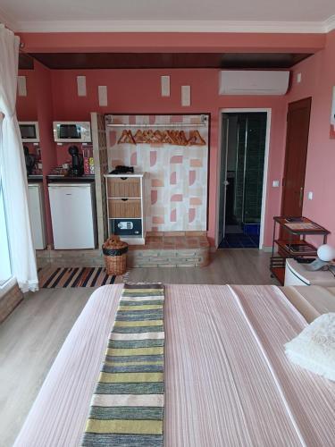 a living room with red walls and a rug at Alojamento local Patudos, Suite com terraço privado in Tavira