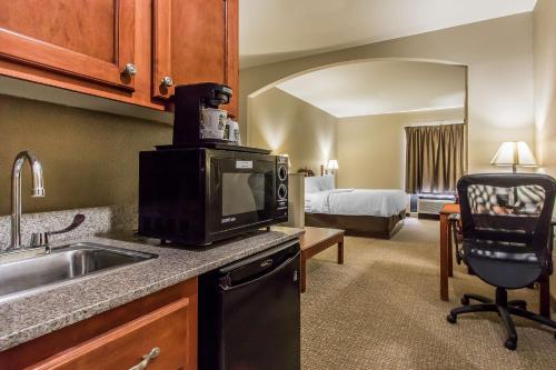 a kitchen with a sink and a microwave at Quality Suites New Iberia in New Iberia